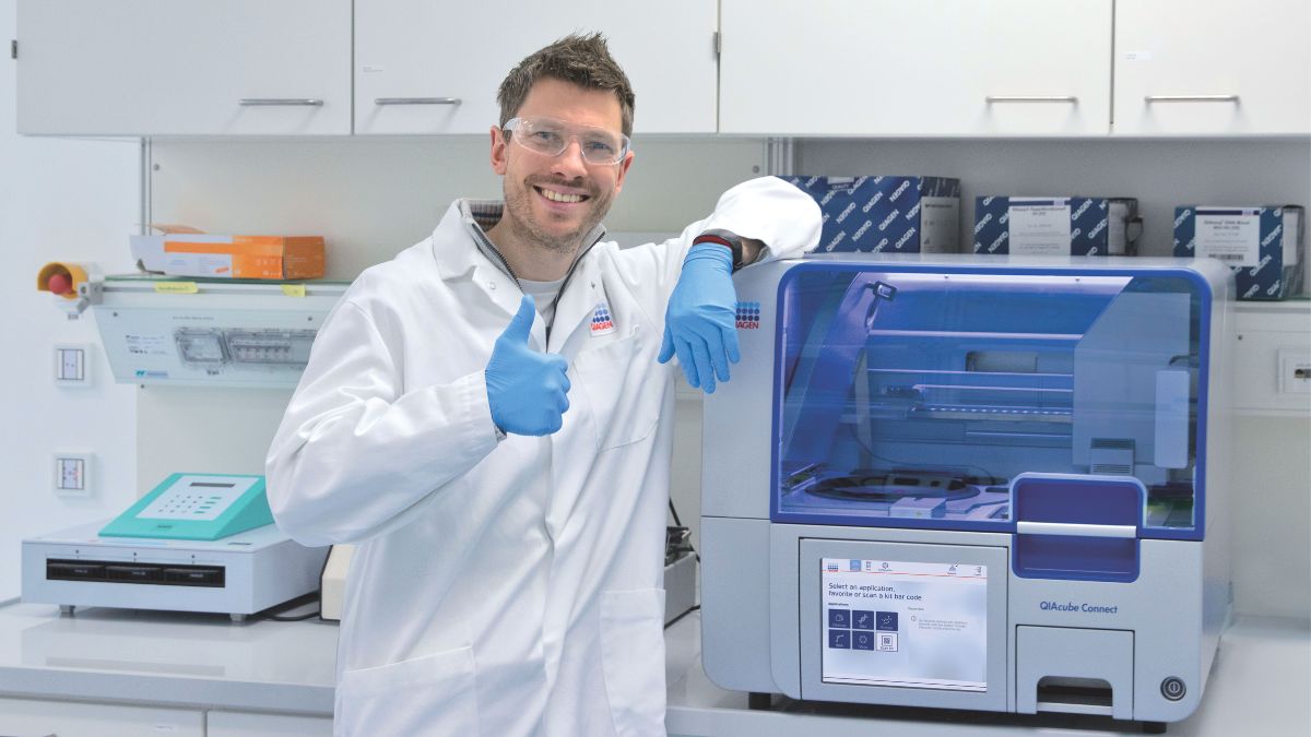 male scientist giving thumbs up to the QIAcube Connect
